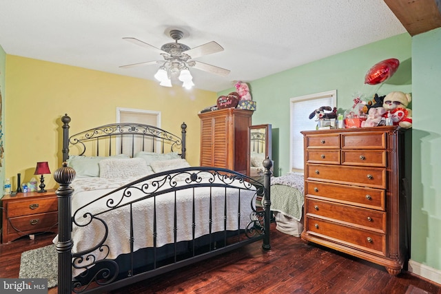 bedroom with ceiling fan, a textured ceiling, and dark hardwood / wood-style floors