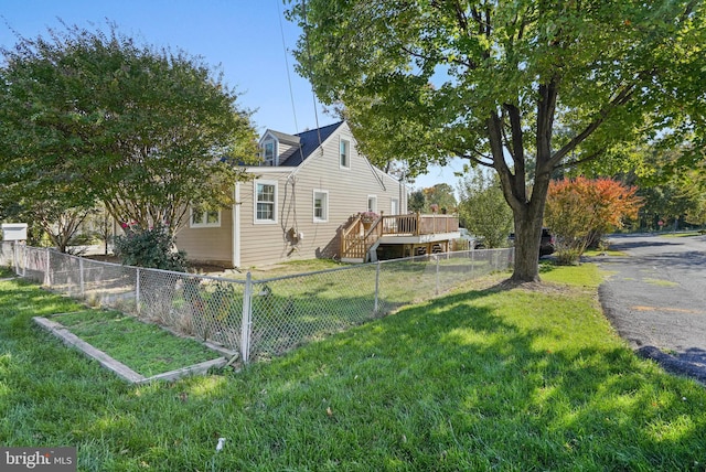 view of side of property with a wooden deck and a yard