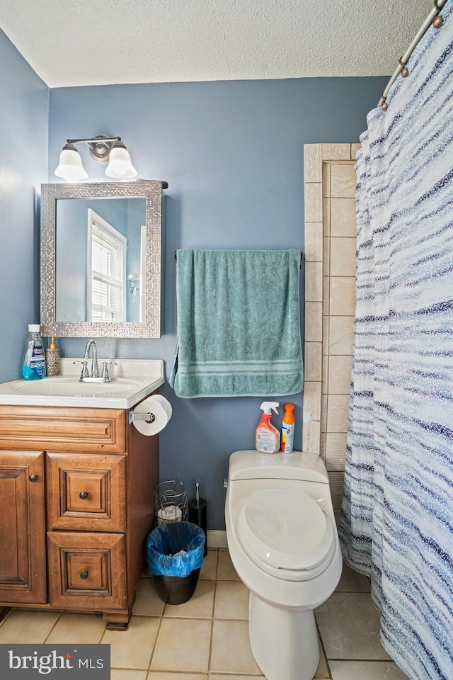 bathroom featuring curtained shower, a textured ceiling, toilet, vanity, and tile patterned flooring