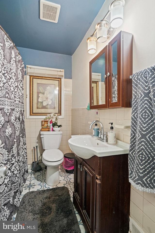 bathroom featuring tile walls, vanity, toilet, and tile patterned flooring