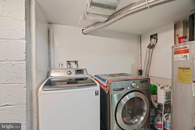 washroom featuring electric water heater and separate washer and dryer