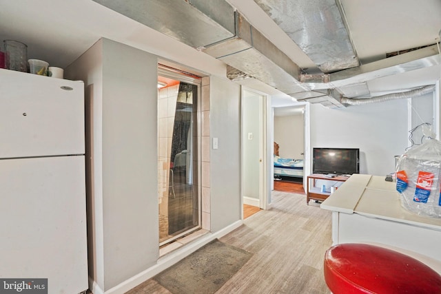 clothes washing area with light hardwood / wood-style floors