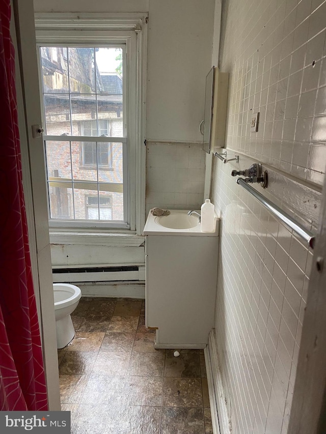 bathroom with vanity, toilet, tile walls, and a baseboard radiator