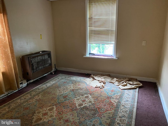 carpeted empty room featuring heating unit