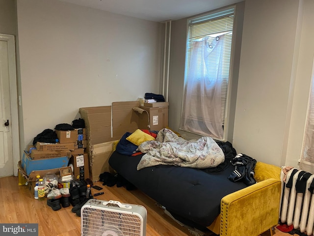 bedroom with radiator and hardwood / wood-style flooring