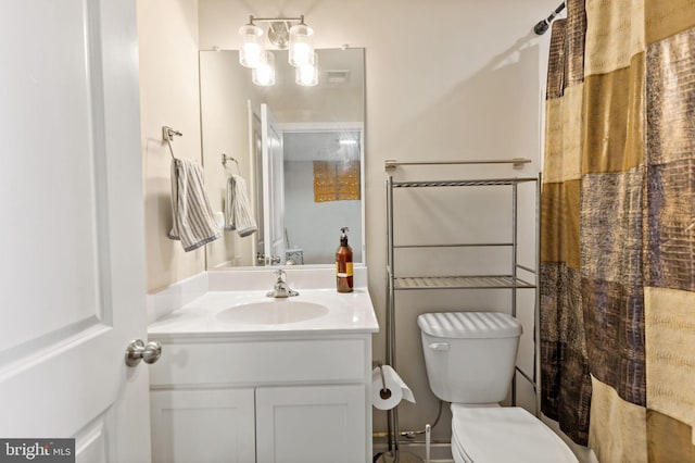 bathroom with vanity, curtained shower, and toilet