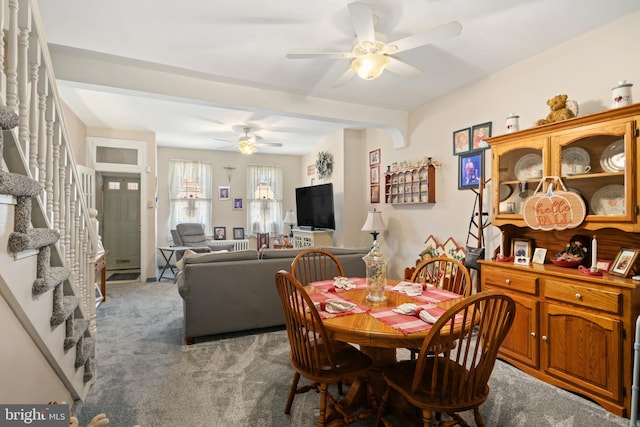 carpeted dining area with ceiling fan