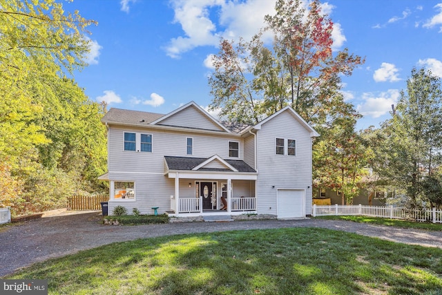 view of front property featuring a porch, a front yard, and a garage