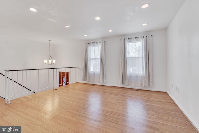 empty room featuring light hardwood / wood-style floors and an inviting chandelier