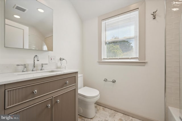 bathroom featuring toilet, vanity, and vaulted ceiling