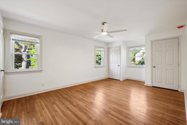 unfurnished bedroom with multiple windows, ceiling fan, and light wood-type flooring