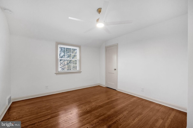 empty room with ceiling fan, dark hardwood / wood-style flooring, and lofted ceiling