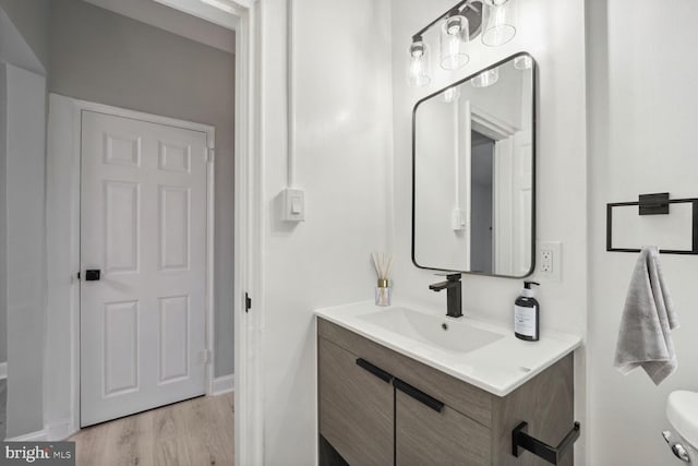 bathroom featuring vanity, hardwood / wood-style floors, and toilet