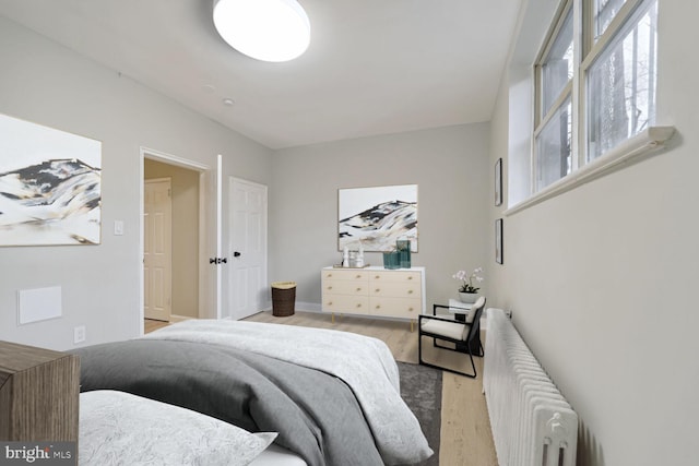 bedroom featuring radiator and light wood-type flooring