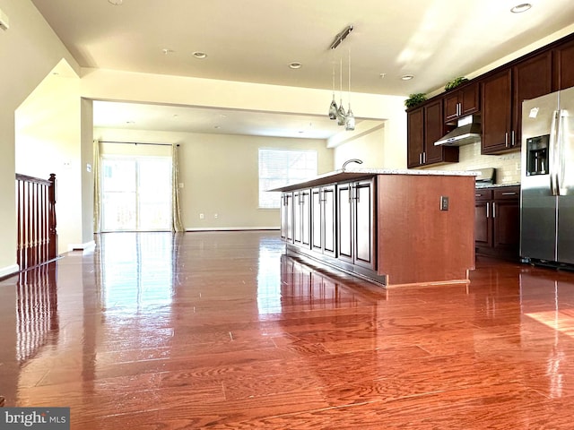 kitchen with tasteful backsplash, sink, dark hardwood / wood-style flooring, stainless steel fridge, and decorative light fixtures