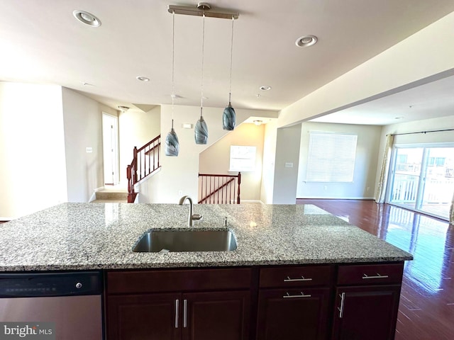 kitchen featuring dark hardwood / wood-style flooring, dishwasher, sink, decorative light fixtures, and light stone counters