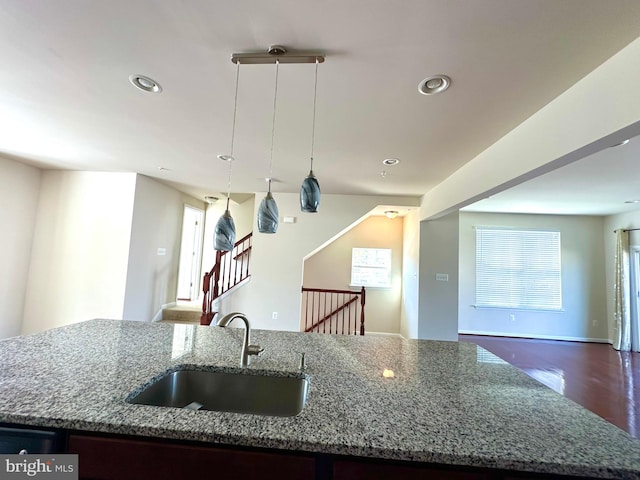 kitchen featuring a center island with sink, sink, hanging light fixtures, and plenty of natural light