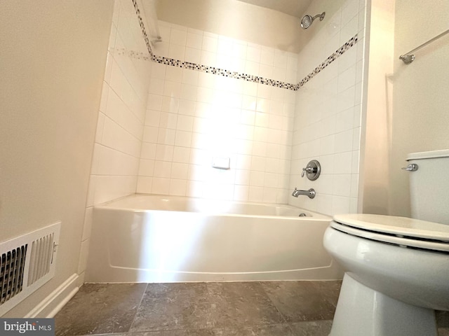 bathroom featuring tiled shower / bath and toilet