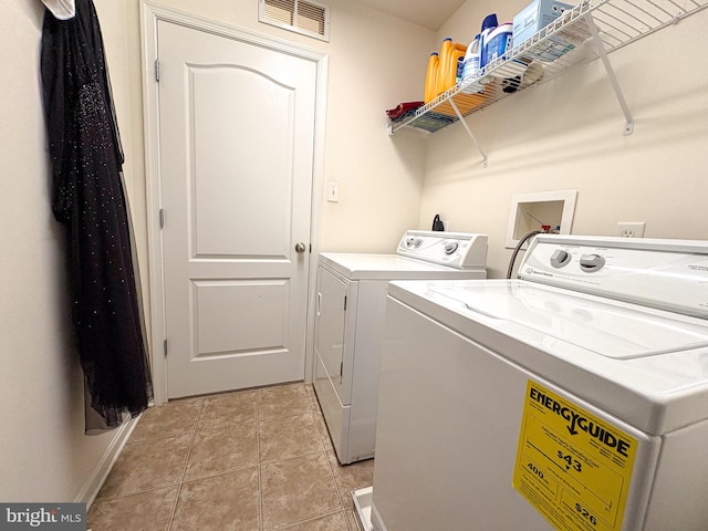 laundry room featuring washing machine and clothes dryer and light tile patterned floors