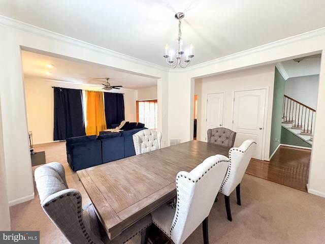 carpeted dining space with crown molding and ceiling fan with notable chandelier