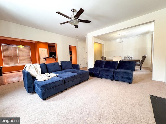 living room with carpet flooring and ceiling fan with notable chandelier