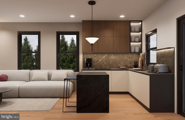 kitchen with dark brown cabinets, sink, pendant lighting, white cabinetry, and light hardwood / wood-style floors