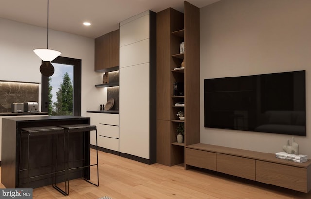 kitchen featuring white cabinetry, light hardwood / wood-style flooring, and decorative light fixtures