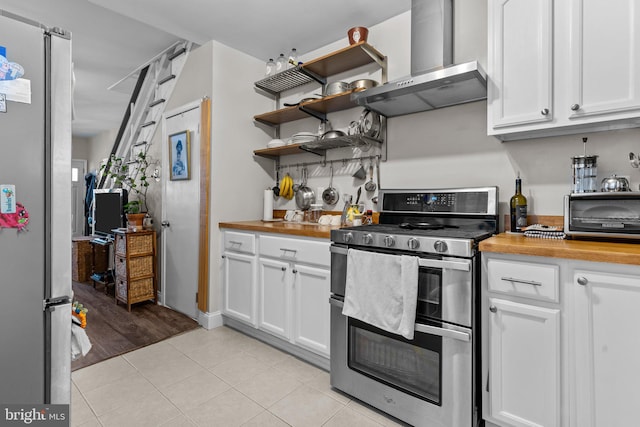 kitchen with extractor fan, stainless steel appliances, wood counters, light wood-type flooring, and white cabinetry