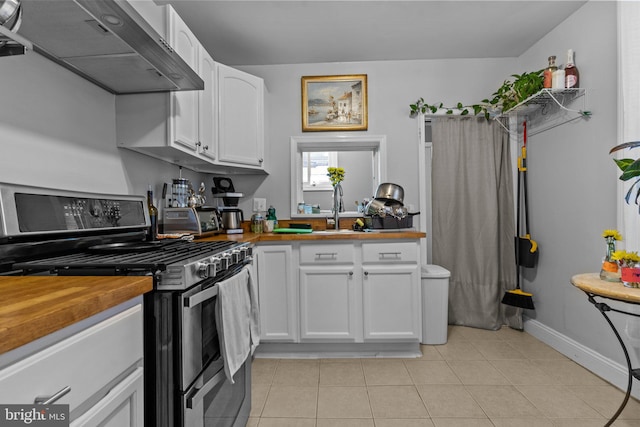 kitchen featuring sink, white cabinetry, light tile patterned flooring, and double oven range