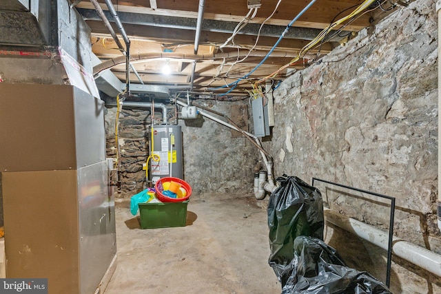 basement featuring gas water heater, electric panel, and heating unit