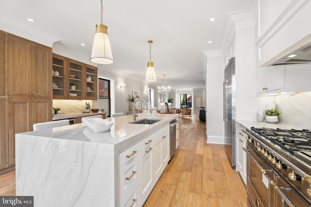 kitchen featuring decorative backsplash, stainless steel appliances, sink, white cabinetry, and a large island