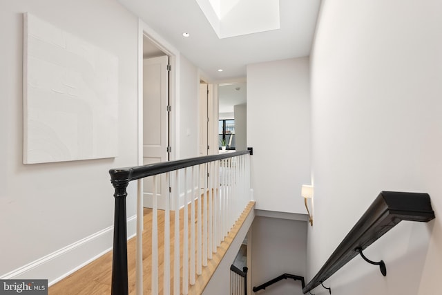 stairway featuring hardwood / wood-style flooring and a skylight