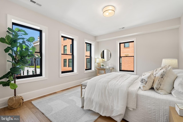 bedroom featuring multiple windows and light wood-type flooring