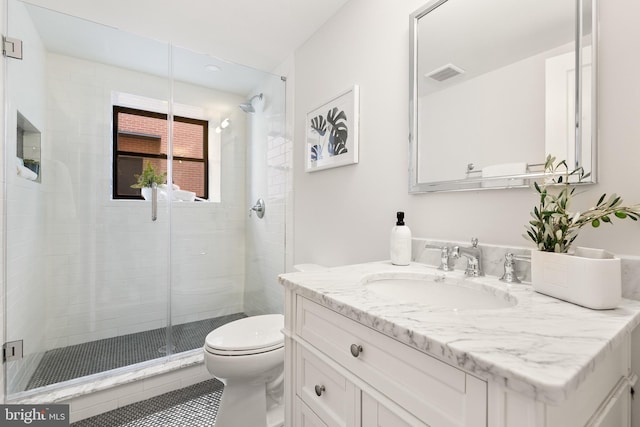 bathroom with vanity, toilet, and a shower with door