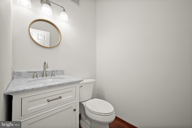 bathroom featuring toilet, vanity, and wood-type flooring