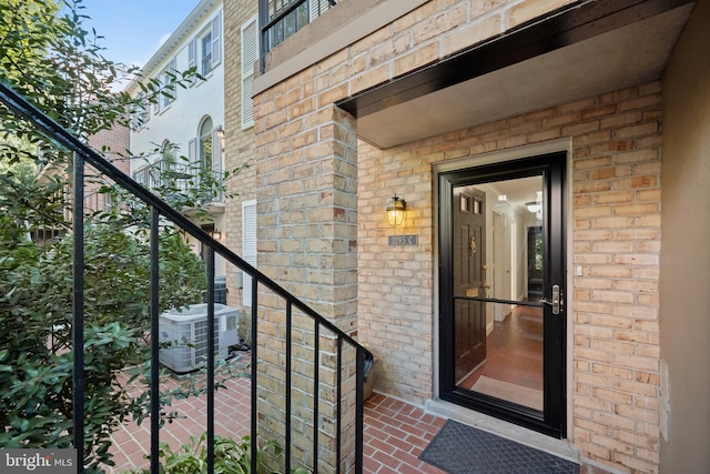 view of exterior entry with cooling unit and a balcony