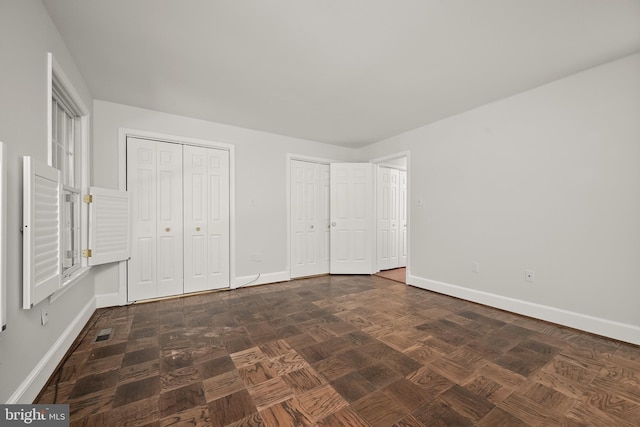 unfurnished bedroom with multiple closets