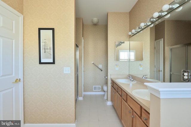 bathroom featuring toilet, vanity, tile patterned floors, and a shower with door