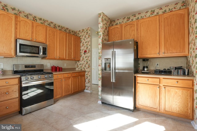 kitchen with backsplash, stainless steel appliances, and light tile patterned floors