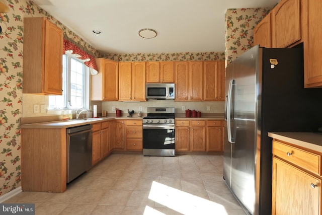 kitchen featuring light tile patterned flooring, stainless steel appliances, and sink