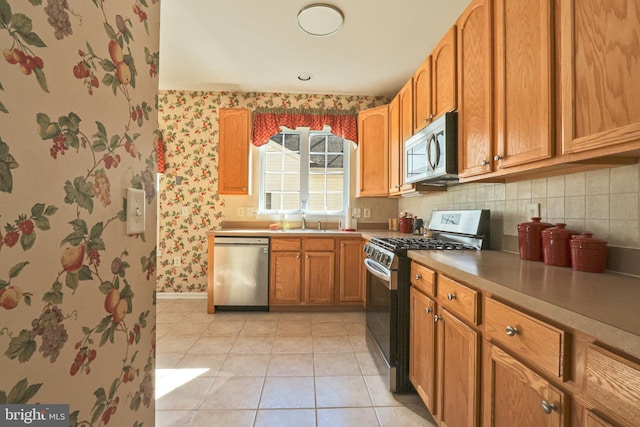 kitchen featuring sink, stainless steel appliances, and light tile patterned floors