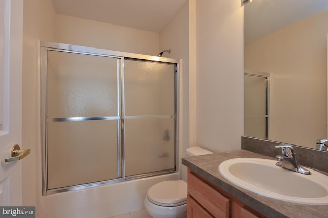 full bathroom with vanity, enclosed tub / shower combo, and toilet