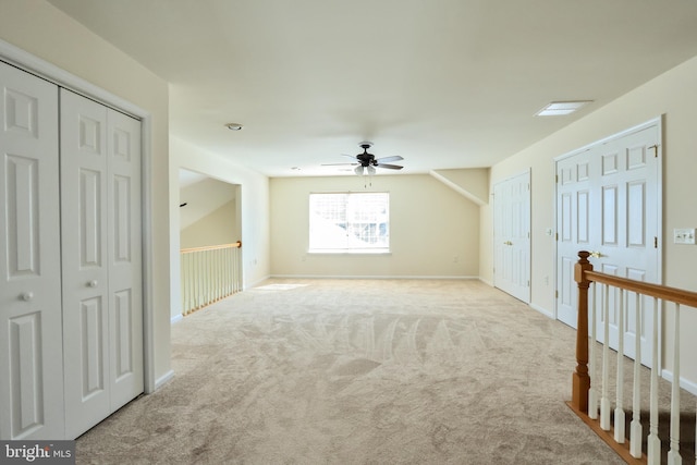 additional living space featuring ceiling fan and light colored carpet