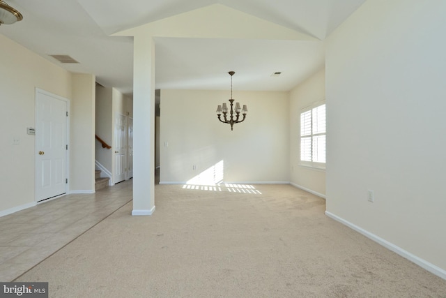 carpeted spare room featuring lofted ceiling and a chandelier