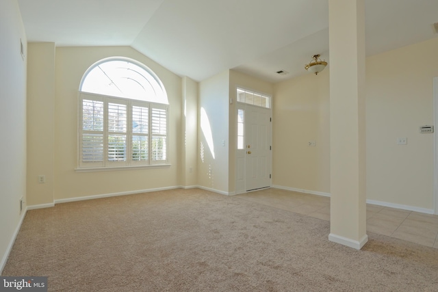 carpeted foyer with vaulted ceiling