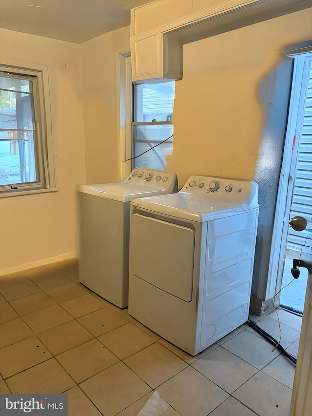 clothes washing area featuring washing machine and dryer and light tile patterned floors