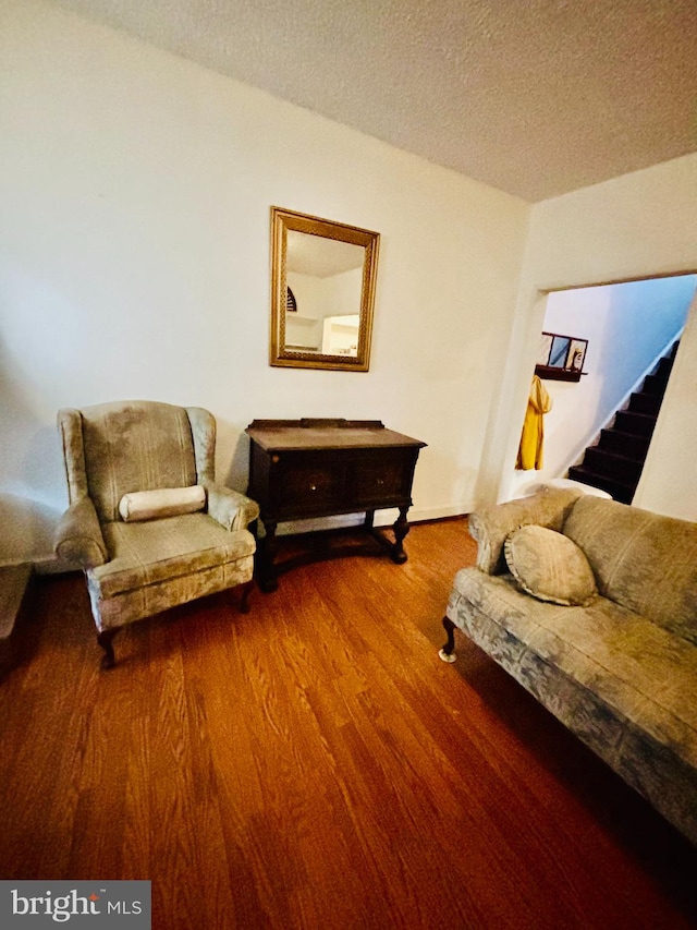 living area with a textured ceiling and hardwood / wood-style flooring