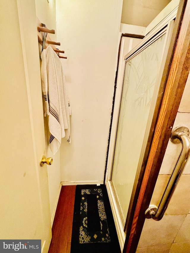 bathroom with wood-type flooring and walk in shower