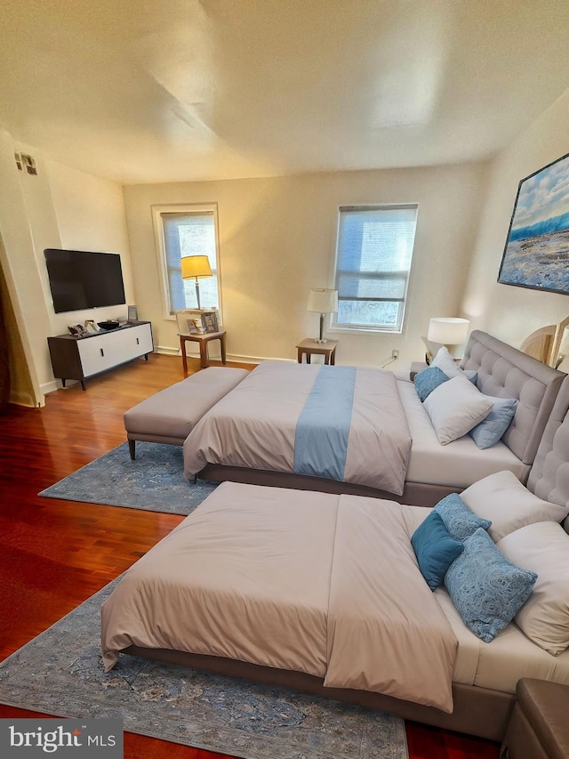 bedroom with multiple windows and hardwood / wood-style floors