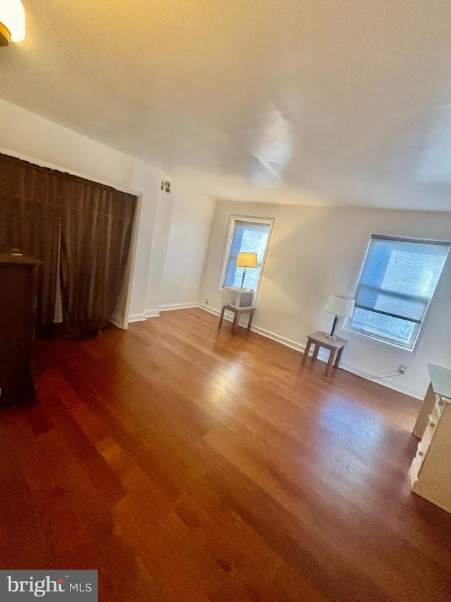 additional living space with a wealth of natural light and hardwood / wood-style flooring